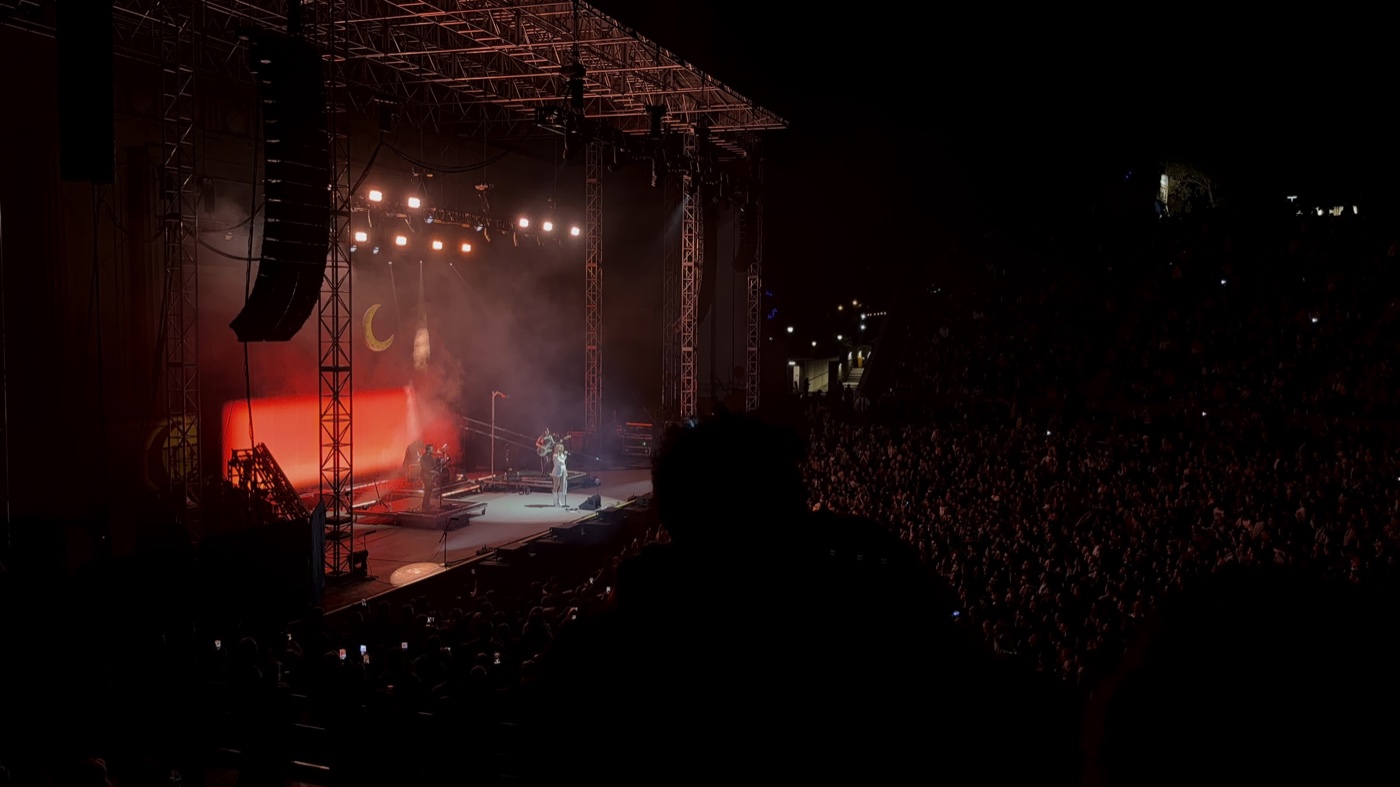 Concert stage with red lighting and a large crowd at a Bob Moses show