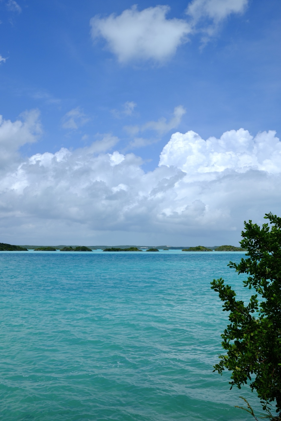 Turquoise water dotted with small islands under a cloudy sky