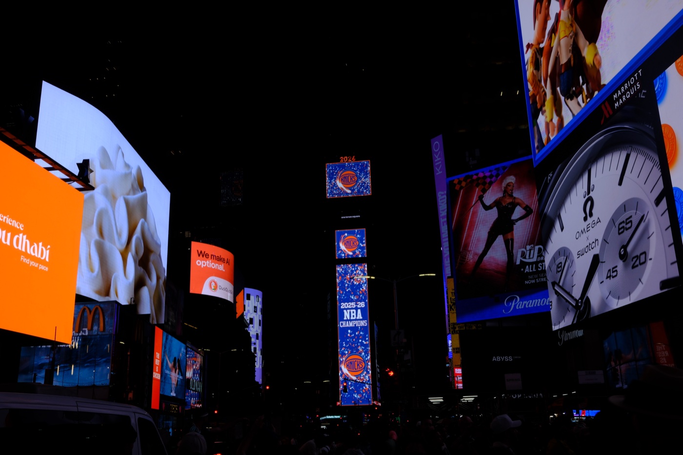 Times Square at night with billboards and a Knicks NBA Champions display