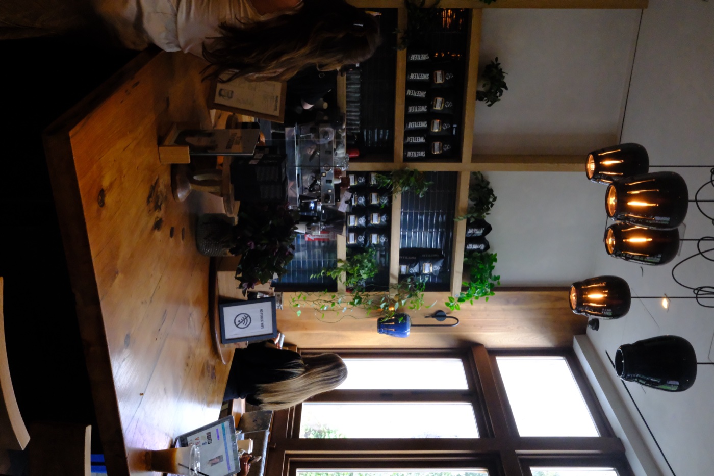 Coffee shop interior with pendant lights and wooden tables
